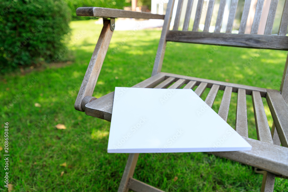Φωτογραφία Mockup of a magazine cover on a wooden chair in the garden in summer