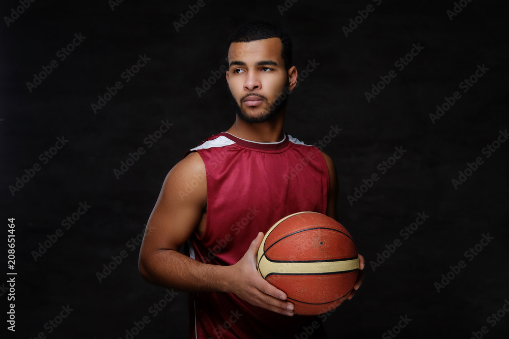 Portrait of an Afro-American sportsman. Basketball player in sportswear with a ball Portrait of an Afro-American sportsman. Basketball player in sportswear with a ball