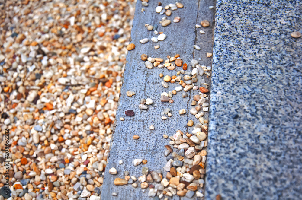 Three stripes of multicolored gravel, grey concrete and speckled marble, summer, Spain Three stripes of multicolored gravel, grey concrete and speckled marble, summer, Spain