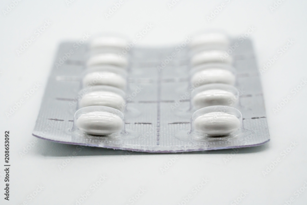 Forefront of a white circle medicine pills in blister pack isolated on white Forefront of a white circle medicine pills in blister pack isolated on white