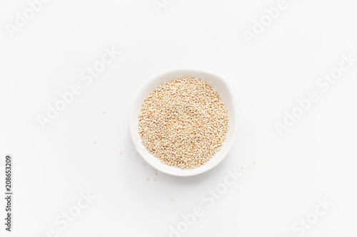 Quinoa in white bowl on white background. Copy space text