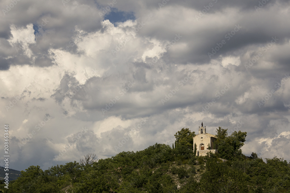 old church on a hill during stormy clouds in the south of france old church on a hill during stormy clouds in the south of france