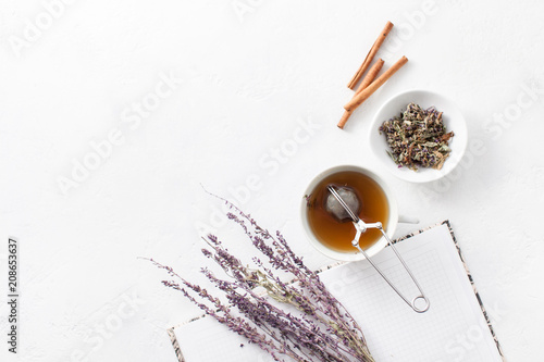 Tea in a Cup with dry flowers on a white table. Copy space text
