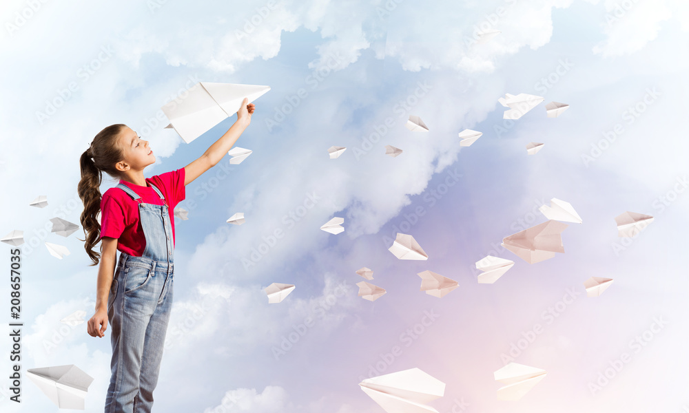 Concept of careless happy childhood with girl throwing paper plane Concept of careless happy childhood with girl throwing paper plane