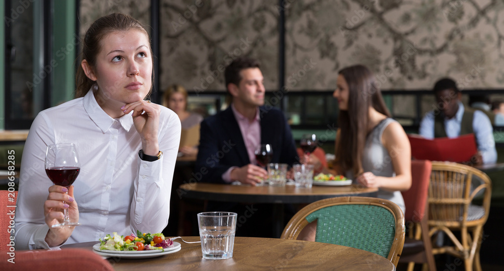 Unhappy young woman alone in restaurant