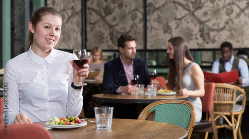 Smiling young woman alone in restaurant