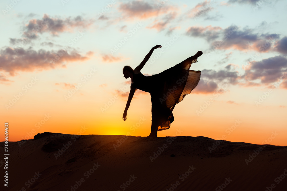 Woman is posing at sunset, she is dancing.