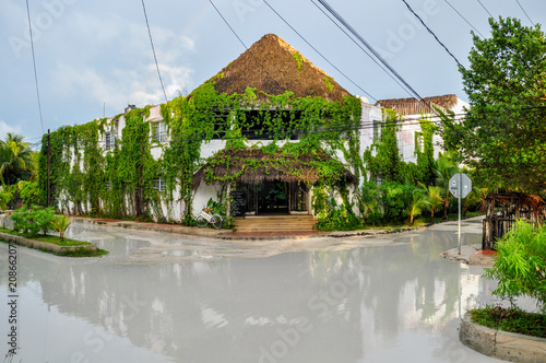 HOLBOX, MEXICO - MAY 25, 2018: Flooded sand roads in the main square of Isla Holbox with tourists and Caribbean houses and shops during sunset