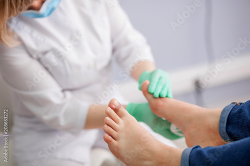 doctor, the podiatrist examines the foot photo