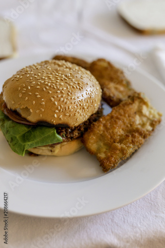 veggie burger bun with courgette fritters on white table setting