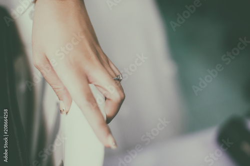 A beautiful diamond ring is worn at the finger of the bride's left hand.