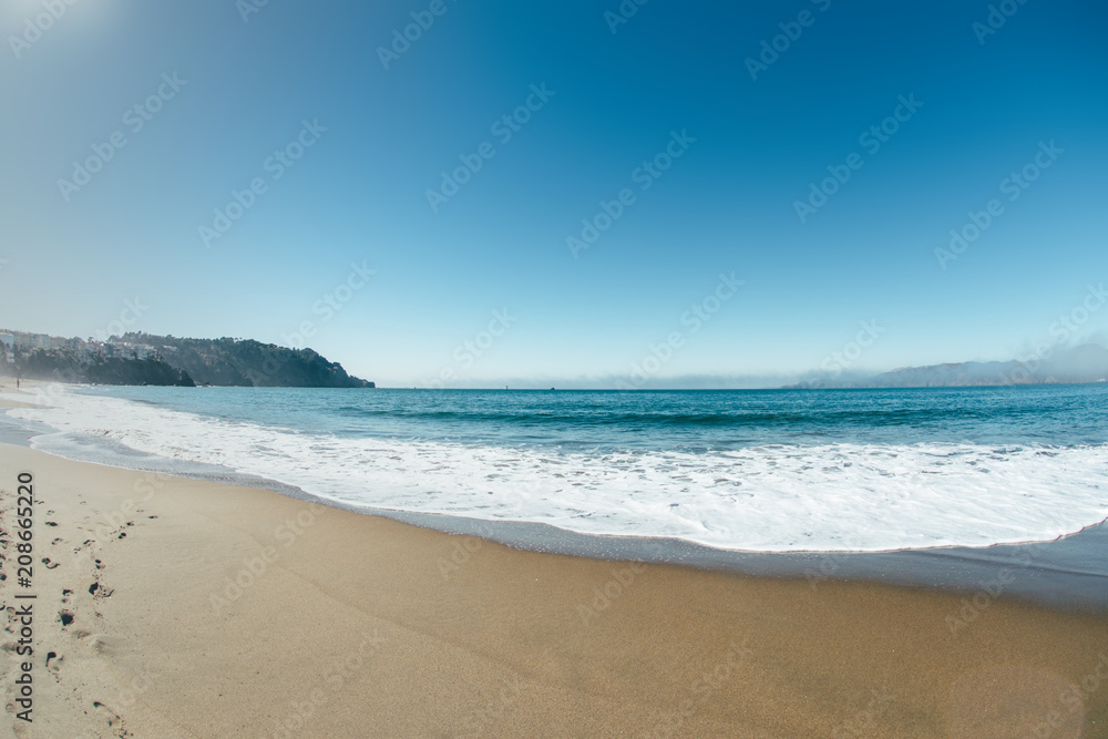 ocean coastline wth waves sunny day with sand