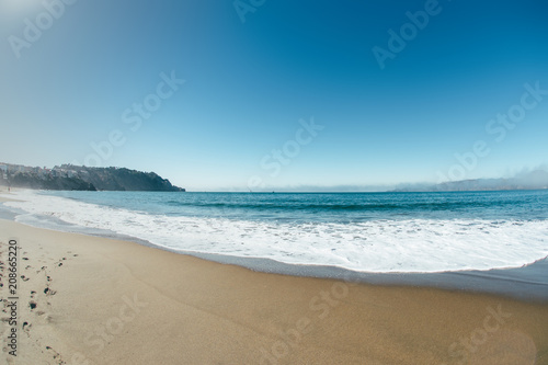 ocean coastline wth waves sunny day with sand