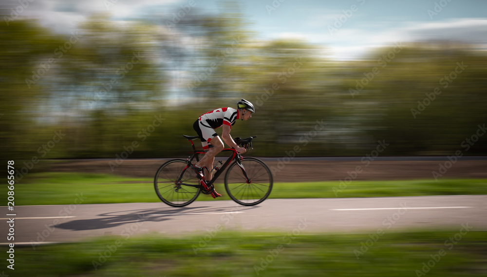 Fototapeta premium Cyclist rides on bicycle, speed effect, side view