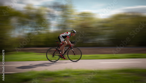 Cyclist rides on bicycle, speed effect, side view