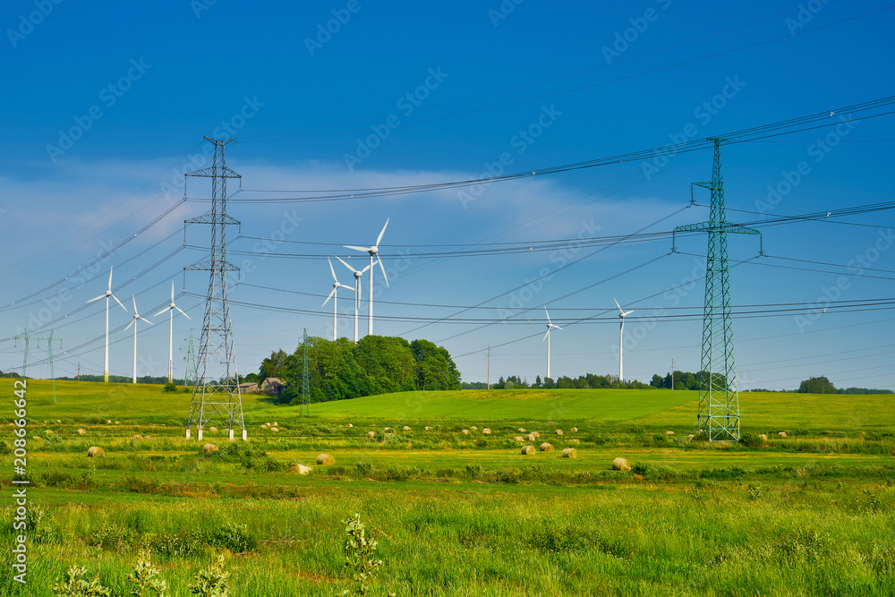 Wind turbines at the meadow against blue sky. Latvia