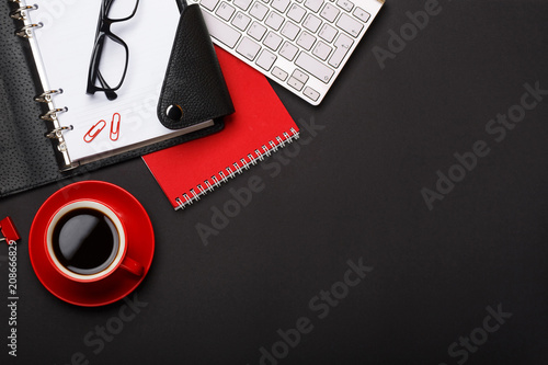 black background red coffee cup note pad alarm clock flower diary scores keyboard empty space desktop