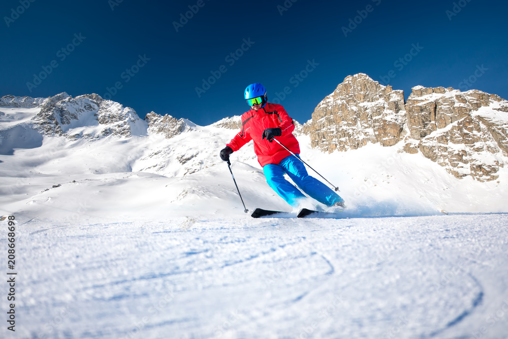 Man skiing on the prepared slope with fresh new powder snow.