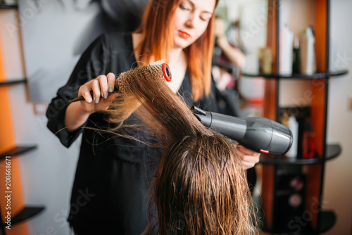 Hairdresser drying hair, female hairdressing