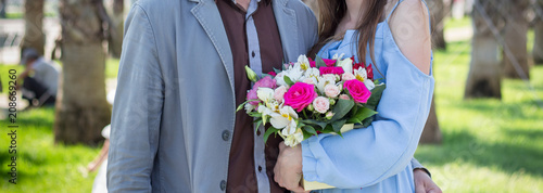 Girl and guy with a bouquet in the park