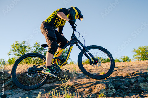 Cyclist Riding the Mountain Bike on the Summer Rocky Trail at the Evening. Extreme Sport and Enduro Cycling Concept. © Maksym Protsenko