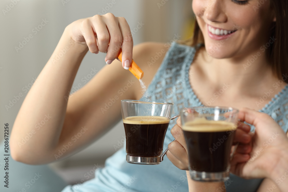 Two women throwing sugar into coffee Two women throwing sugar into coffee