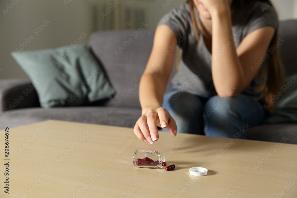 Worried woman catching antidepressant pills Worried woman catching antidepressant pills