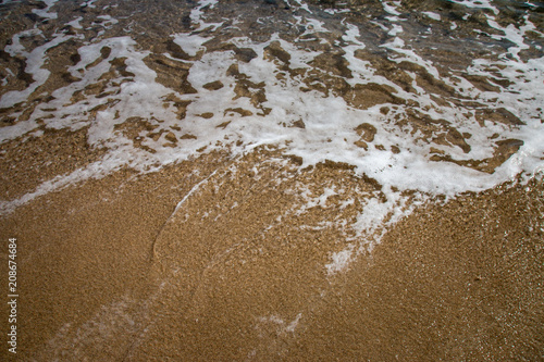 Sea foam and soft wave on a sand beach
