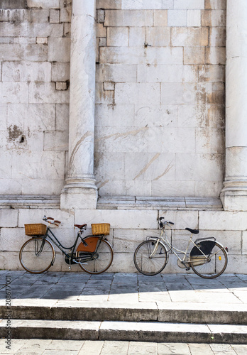 Bikes against a textured wall in Lucca, Tuscany, Italy