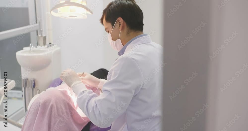 Caucasian dentist treating teeth to woman patient in clinic. Dental check up Caucasian dentist treating teeth to woman patient in clinic. Dental check up