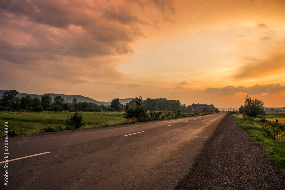 orange sunset evening country side landscape with lonely road concep