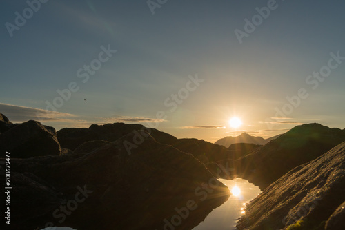 Reflections at Rorvikstranda beach and Gimsoystraumen fjord at Lofoten Islands / Norway at sunset photo