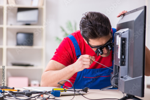 Professional repair engineer repairing broken tv photo