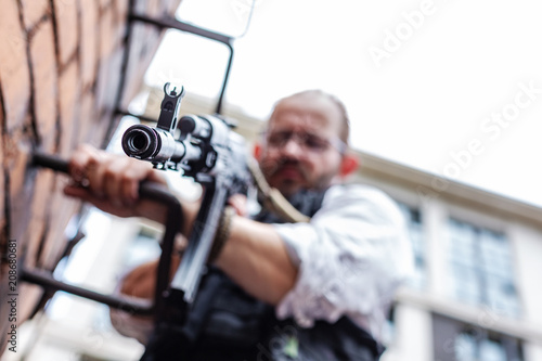 Powerful man Holding Gun. War Action Movie Style