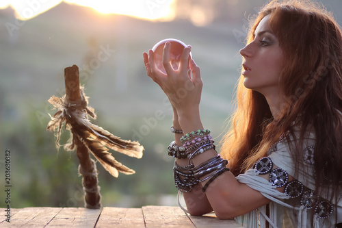 witch with crystal ball at sunset