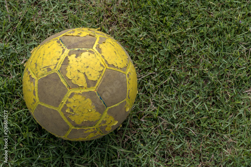 Close-up of old football lying on grass.