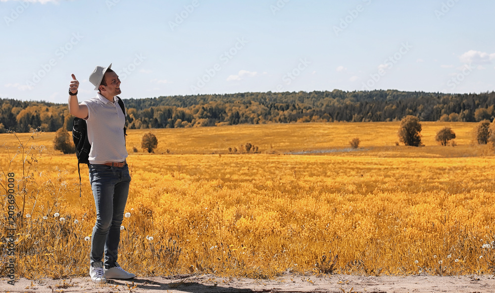 A young man is traveling in nature. Traveling with a backpack on