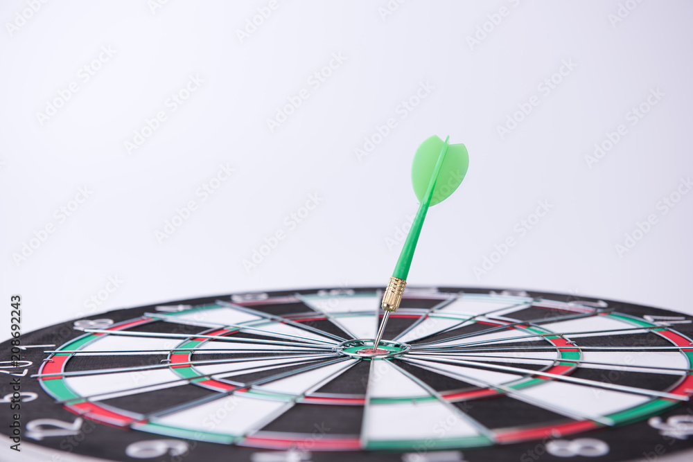 Fototapeta premium On the Target. Green dart hitting the target.