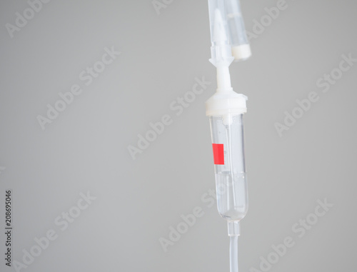 Saline with valves and joints for medication drops and red stickers.