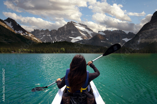 Person kayaking in beautiful blue lake with mountain scenery, peaceful travel adventure 
