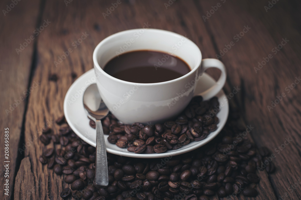 Coffee cup with coffee beans on wood table. Coffee cup with coffee beans on wood table.