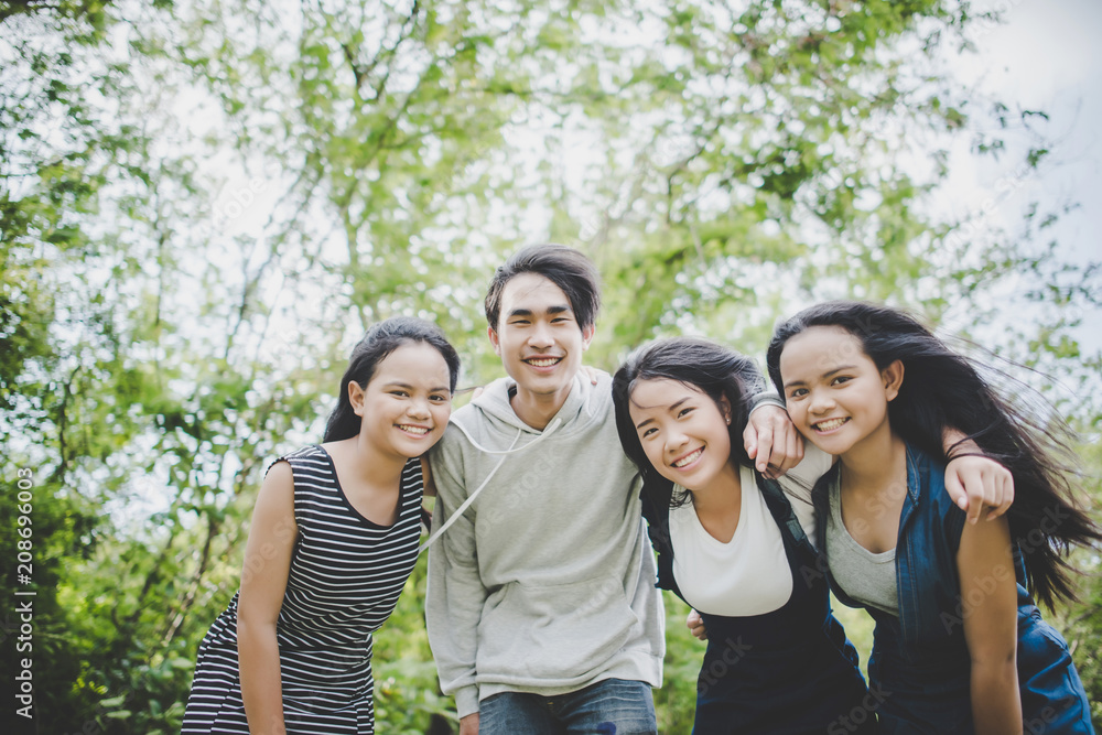 Happy teenage friends smiling outdoors at the park Happy teenage friends smiling outdoors at the park
