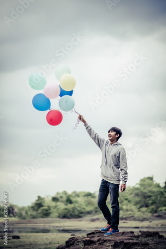 Young man hand holding colorful balloons © Johnstocker