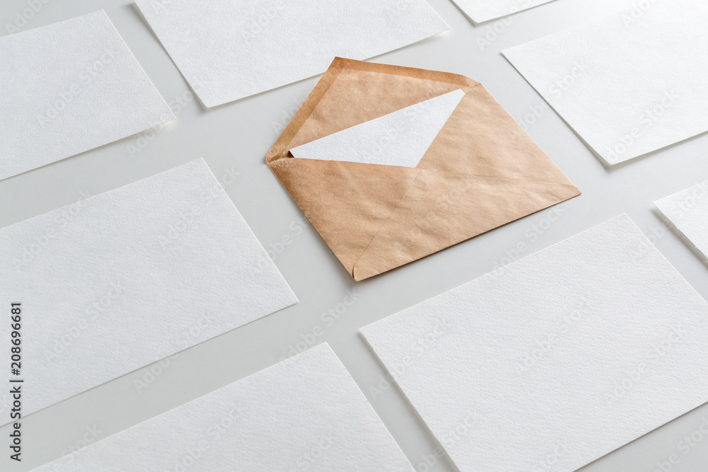 Mockup of horizontal business cards stacks arranged in rows and brown envelope in center Mockup of horizontal business cards stacks arranged in rows and brown envelope in center