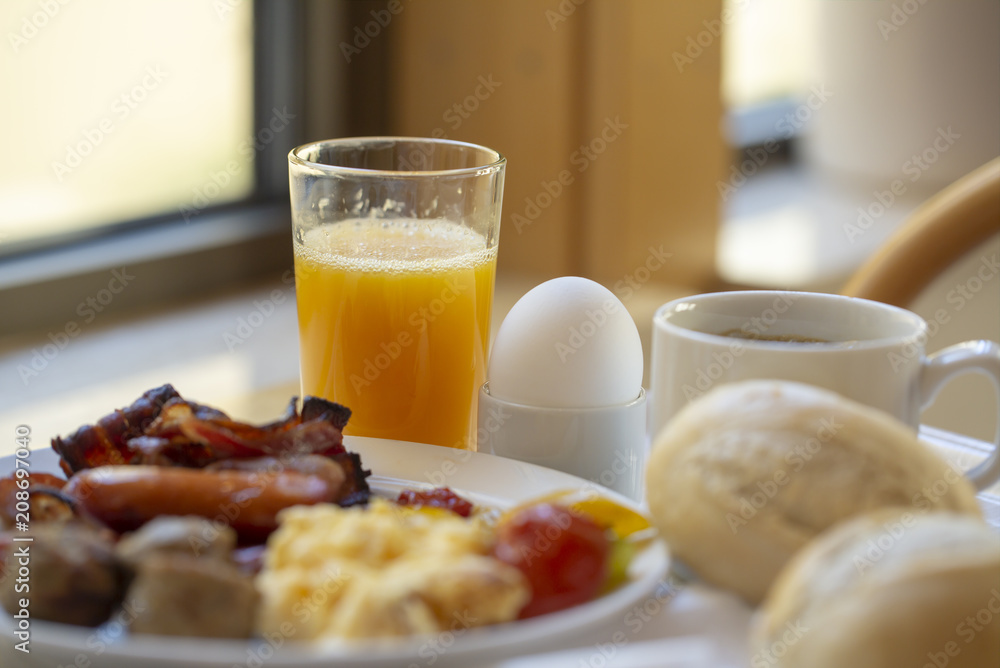 Boiled eggs ,sausages, meat ball, Bread and bacon, Orange juice, Cup of black coffee, Sliced Sweet Pepper and ham on plate, healthy breakfast. Boiled eggs ,sausages, meat ball, Bread and bacon, Orange juice, Cup of black coffee, Sliced Sweet Pepper and ham on plate, healthy breakfast.