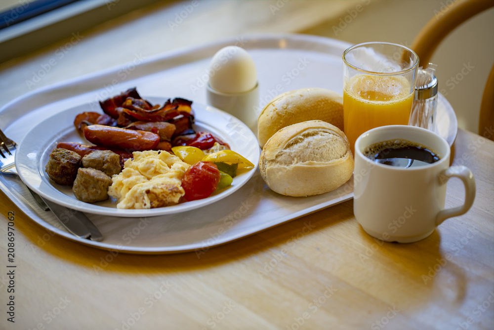 Boiled eggs ,sausages, meat ball, Bread and bacon, Orange juice, Cup of black coffee, Sliced Sweet Pepper and ham on plate, healthy breakfast.