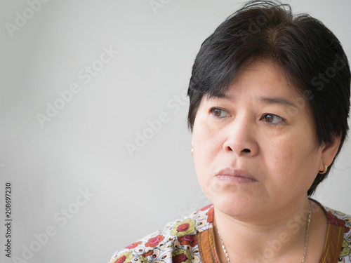 Sad woman sitting in a red chair.