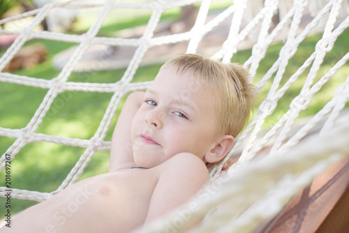 cute little boy is resting in a hammock © klavdiyav