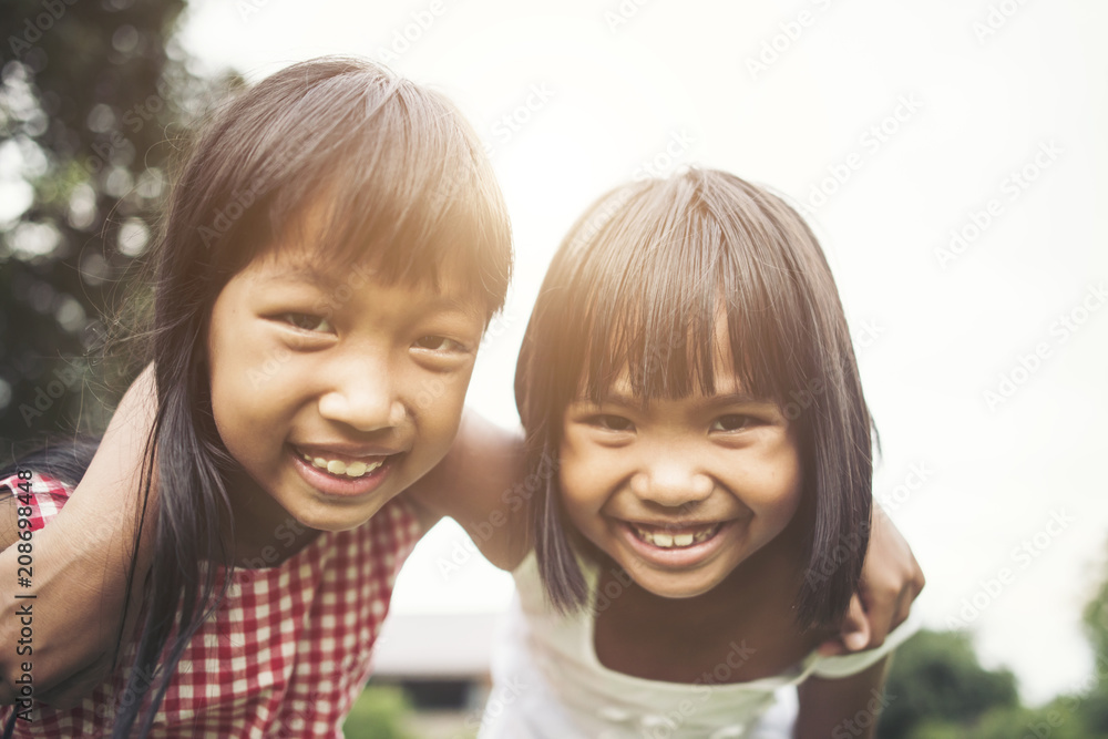 Two little girls friends playing funny in the park Two little girls friends playing funny in the park