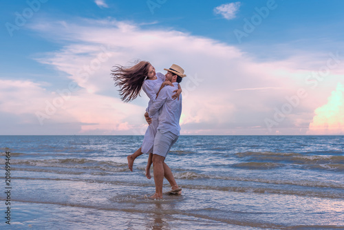 Canvas Print Happy young couple holding each other and laughing with enjoying together on the summer beach, romantic couple spending time concept
